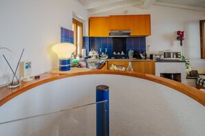 A kitchen with wooden cabinets, a microwave, and a sink.