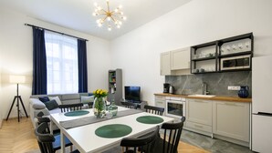 Una cocina moderna con microondas, cafetera y copas de vino en estantes.