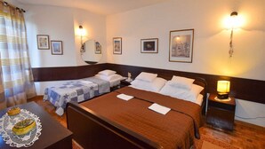 Ein Hotelzimmer mit zwei Betten, einem kleinen Tisch und einer Dekoration sowie Wandlampen.