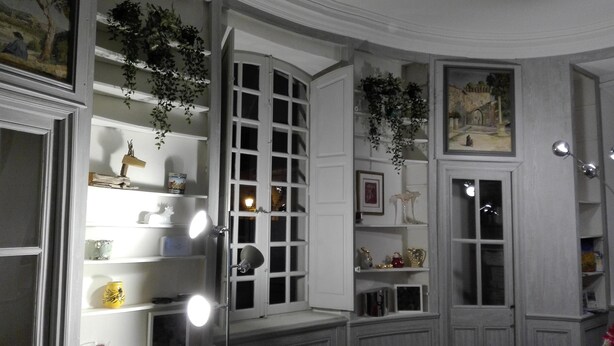 A room with a large bay window, shelves with decorative items, and hanging plants. - 10' from St Rémy and Avignon, charming apartment ***, 2 bedrooms for 4 people (Noves)
