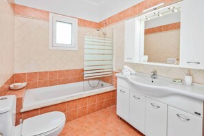 Een bad/douchecombinatie, handdoeken