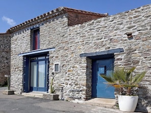 A stone building with two blue doors and a small window. - Opuntia (Téoulièro), air-conditioned house in a quiet Mediterranean village (Escales)