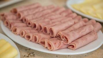 A plate of sliced ham arranged neatly on a white plate.