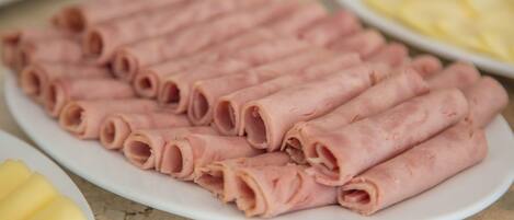 A plate of sliced ham arranged neatly on a white plate.