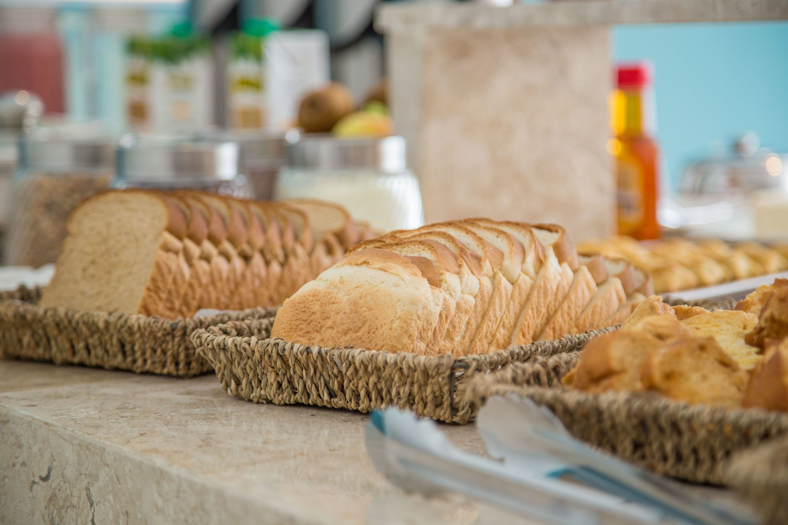 A buffet table with various breads and pastries.