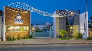 Entrada d'hotel amb disseny modern, amb un logotip destacat i façana de vidre.
