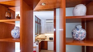 A kitchen with wooden shelves, a microwave, and a refrigerator.