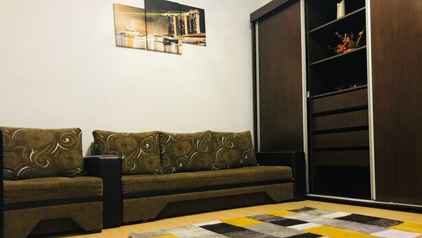 A living room with a sofa, a coffee table, and a bookshelf. - Andreti  Studio Circus Park (Sector 2)