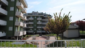 A multi-story residential building with balconies, a central courtyard, and a small garden area. - Bnbook-Metropolitan Expo Flat 4 Bilocale con wifi veloce (Rho)