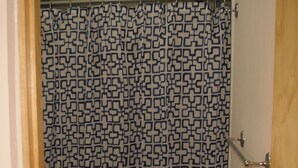 Une salle de bain avec un rideau de douche à motifs, des toilettes et un lavabo.