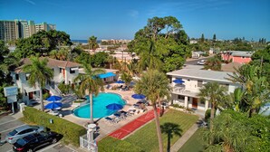 Un complexe hôtelier doté d’une piscine, de chaises longues et de palmiers.