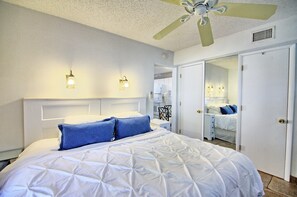 Ein Hotelzimmer mit einem großen Bett, einem Deckenventilator und zwei Wandleuchten.