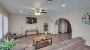 A spacious living room with a brown leather sofa, a wooden coffee table, and a ceiling fan. - 2 Mi to Lake Havasu: Private Oasis w/ Pool & Views (Lake Havasu City)