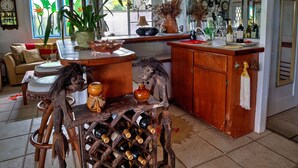 Una cocina amplia con un aparador para vinos, un comedor con sofá, y un cartel que anuncia un evento público.