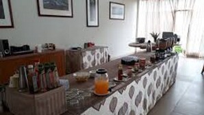 A kitchen with a long counter, various kitchen appliances, and a refrigerator. - Royal Cashrise lodge (Kabwe)
