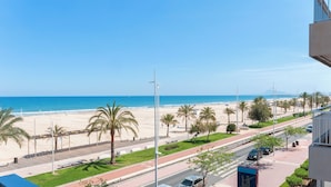 A coastal road with palm trees, a beach, and a clear blue sky. - PIROPO - Apartment with sea views in Playa de Gandia. (Grau i Platja)
