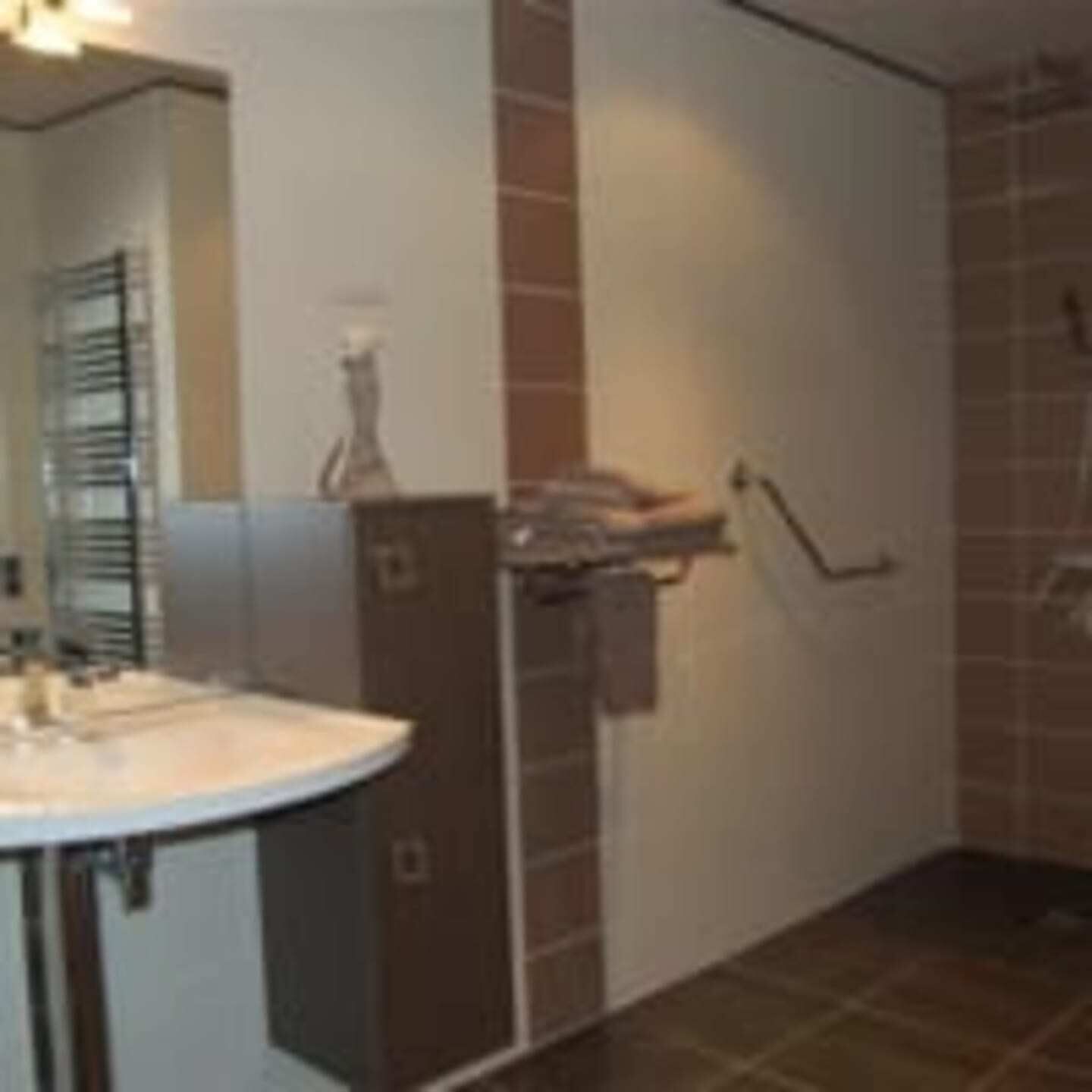 Une salle de bain équipée d’un lavabo, d’un miroir et d’un porte-serviettes.