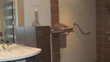 Une salle de bain équipée d’un lavabo, d’un miroir et d’un porte-serviettes.