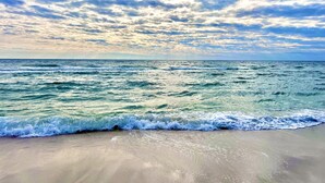 Une plage avec des vagues et un ciel nuageux.