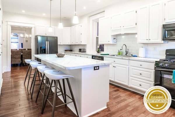 The custom, fully equipped chef’s kitchen with a marble top breakfast bar