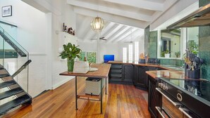 A modern kitchen with a wooden countertop, black cabinets, and a built-in stove.