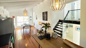 A spacious kitchen with a dining area, a staircase, and a view of the outdoors.