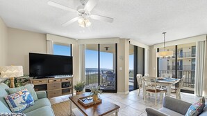 Un salon spacieux doté d’un téléviseur à écran plat, de sièges confortables, d’un coin repas et d’un balcon avec vue.
