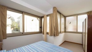 Una habitación con cama, ventana y puerta.