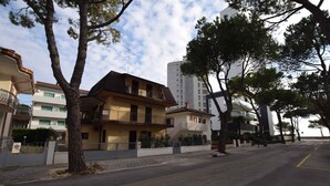 Una calle residencial con edificios de varios pisos, árboles y cielo despejado.