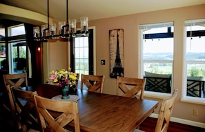 Enjoy meals with family and friends in this dining area, featuring a table for six and a beautiful view of the outdoors.