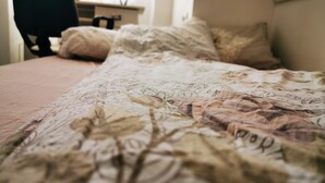 A bed with a floral patterned bedspread and pillows. - Ultra Central apartment (Oradea)