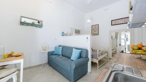 A compact living space with a kitchenette, a dining area, and a sofa.