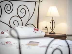 Cozy retreat with a neatly made bed, bedside table, and warm lighting.