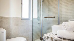A modern bathroom with a glass-enclosed shower, a toilet, and a stack of white towels. - Villa Della Luna - Three Bedroom Villa, Sleeps 6 (Vlachata)