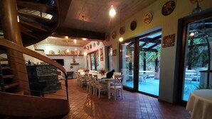 Un restaurant doté d’un escalier en colimaçon, de tables, de chaises et offrant une vue sur l’extérieur.