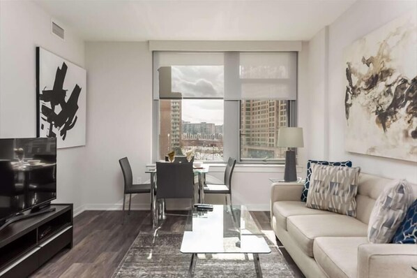 Relax in this stylish living room with a flat-screen TV, glass coffee table, and comfortable sofa.