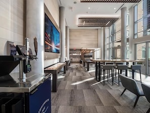 A modern hotel lobby with a coffee bar, seating area, and large windows. - Bright 1BR | Ideal for Business | Balcony Apartment | Crystal City Arlington | by GLS (Arlington)
