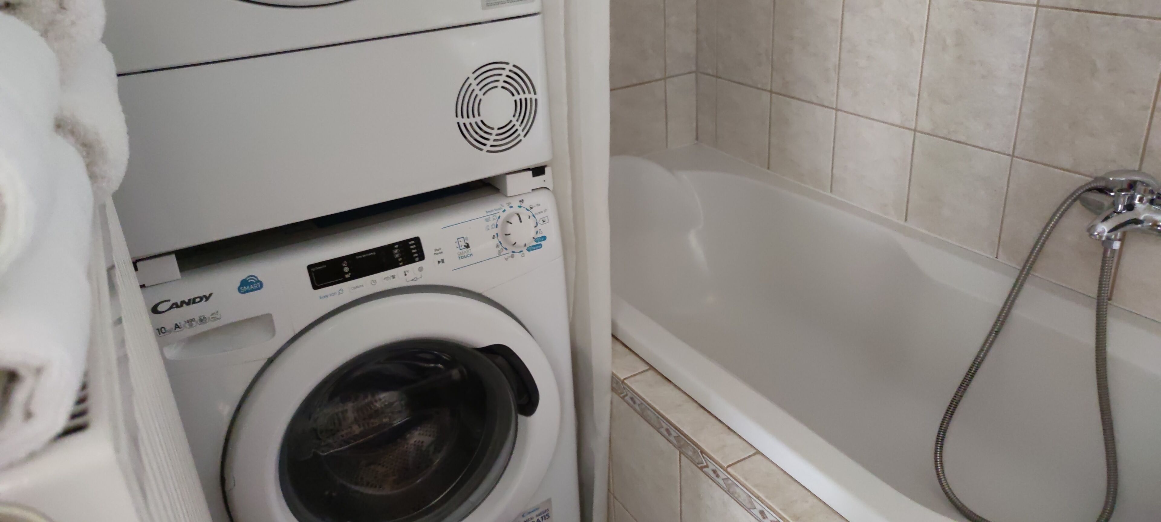 Máquina de lavar roupa e banheira em um banheiro.