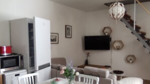 Um espaço compacto com cozinha compacta, área de refeições e escada.