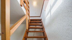 A wooden staircase in a room with white walls and a light fixture on the ceiling. - Stunning private villa for 3 people with A/C, WIFI, TV, patio and pets allowed (Moneglia)