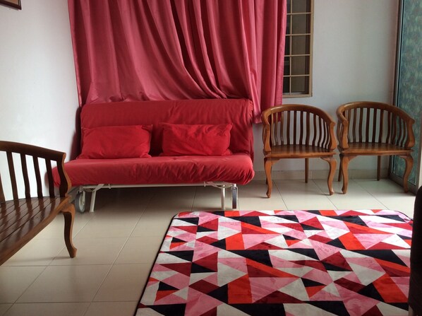 Relax in this stylish room with a sofa, two chairs, and a vibrant rug.