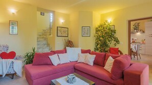 A living room with a red sofa, a coffee table, and a staircase leading to an upper floor. - Beautiful  villa for 4 people with WIFI, TV and terrace (Massa)