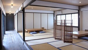 Une pièce de style japonais traditionnel, avec un sol recouvert de tatamis, une petite table en bois et une porte coulissante.