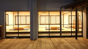 Une pièce de style japonais traditionnel, avec un sol recouvert de tatamis, des portes coulissantes et un lit bas en bois.