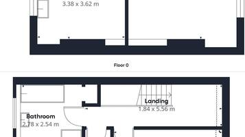 Een plattegrond van een hotelkamer met een doorgang, hal, keuken, woonkamer, badkamer en twee slaapkamers.
