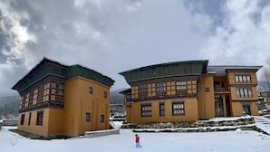 Dos edificios tradicionales con estilos arquitectónicos diferentes, que presentan múltiples ventanas y un cimiento de piedra.
