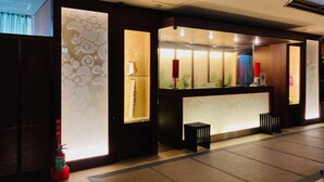 A reception area with a modern design, including a reception desk, a fire extinguisher, and a small trash bin. - Hotel Sol - Adults Only (Fukuoka)