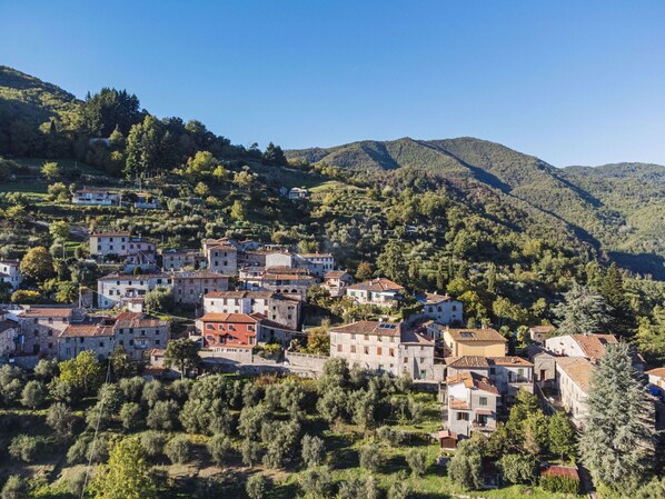 A hillside village with stone buildings and terraced fields.