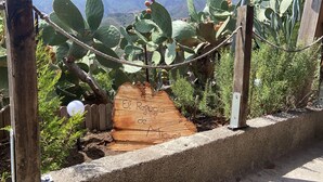 Un sentier en bois, agrémenté d’un panneau indiquant : « El Roguio de Aigues ».