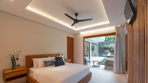 Une chambre moderne avec un grand lit, un ventilateur de plafond, une télévision et une vue sur une terrasse extérieure.